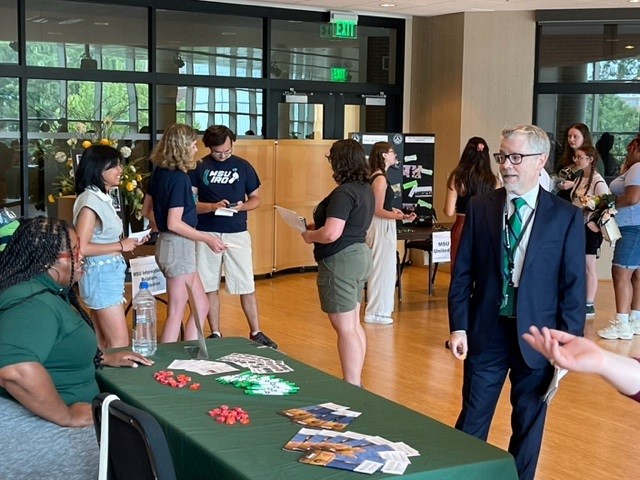 Dean Dr. Brent Donnellan speaks to a student at Colloquium 2023. 